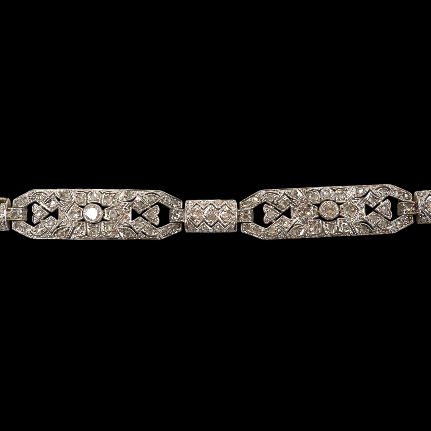 An early 20th century pierced white gold and millegrain set diamond cluster bracelet, set with round and rose cut stones, 18.1cm, gross weight 18.1 grams. Condition - fair to good